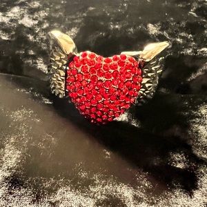 Silver metal bangle with wings and red crystal encrusted heart.